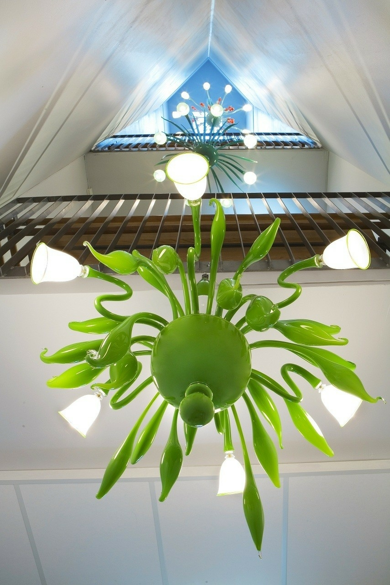 Verket består av fem lysekroner i blåst og frhåndsformet glass montert rundt armatur i stål og aluminium.