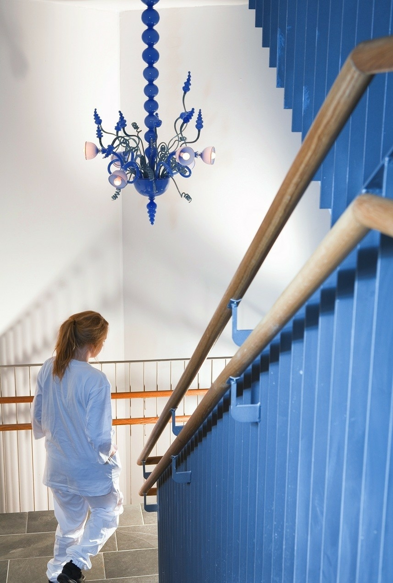 Verket består av fem lysekroner i blåst og frhåndsformet glass montert rundt armatur i stål og aluminium.