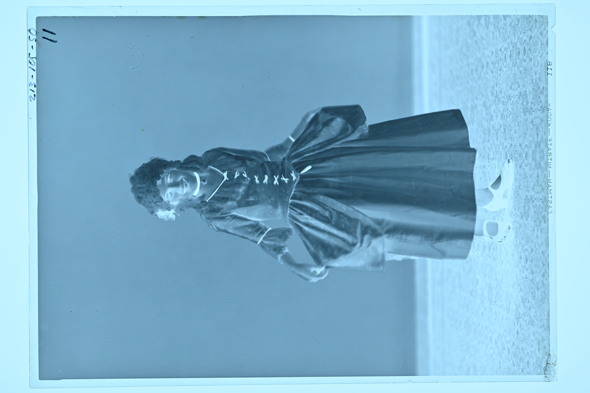 Flicka i klänning och peruk.