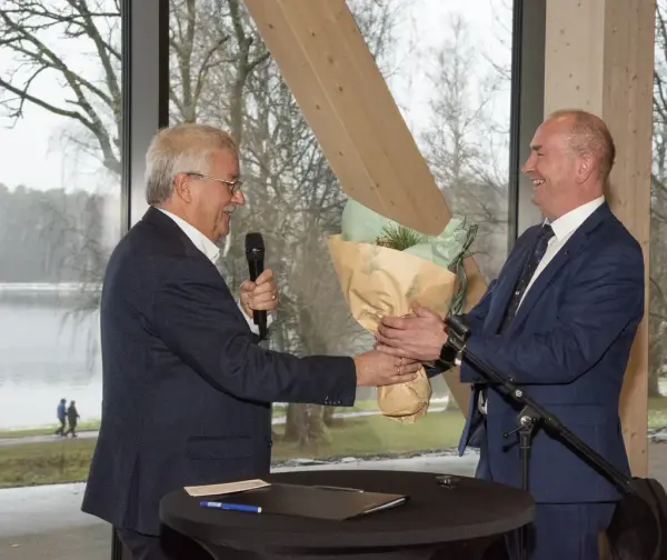 Styreleder i Sparebankstiftelsen Hedmark, Richard Heiberg, overleverer gratulasjonsblomster til Sven Inge Sunde i Anno.