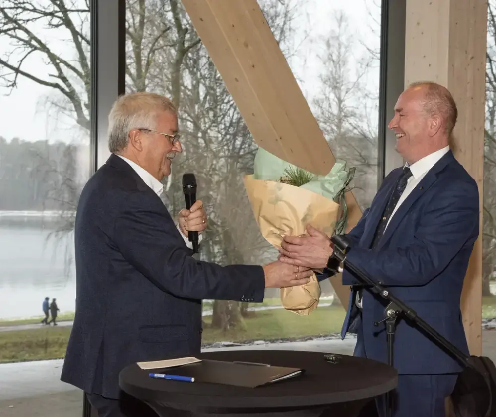 Styreleder i Sparebankstiftelsen Hedmark, Richard Heiberg, overleverer gratulasjonsblomster til Sven Inge Sunde i Anno.