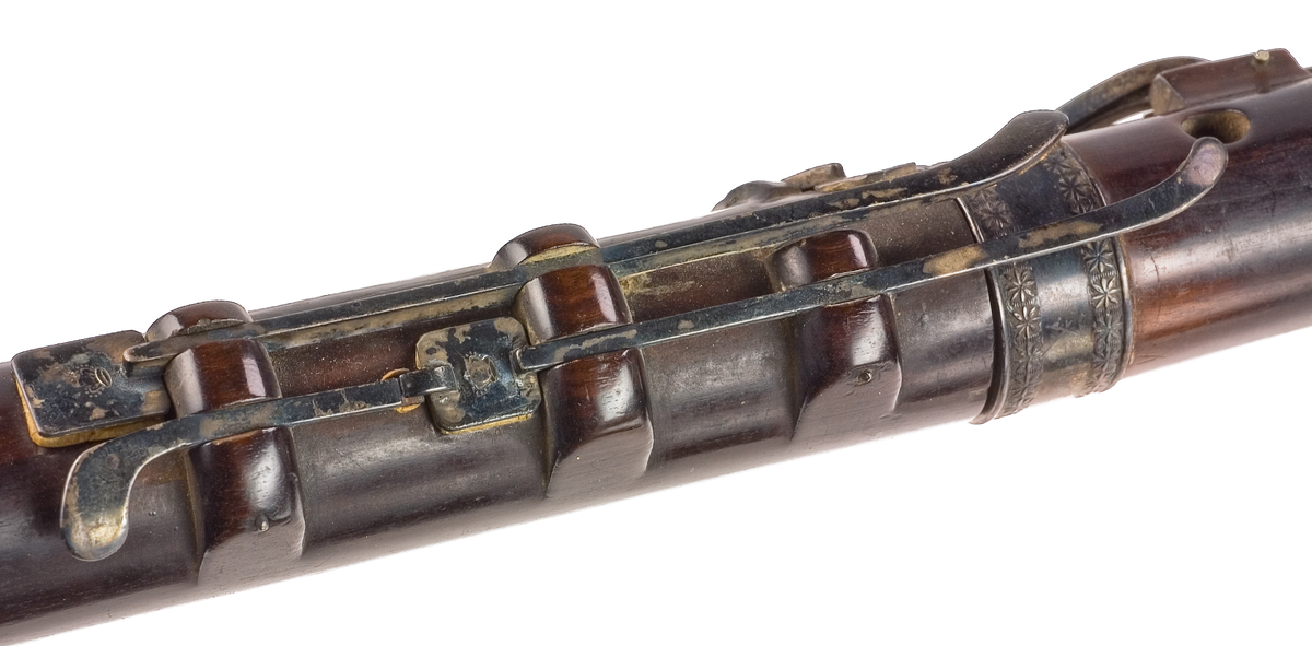 Tvärflöjt i ebenholts med ringar av silver och mörkt horn, med blommönster. 3 delar. C-fot. 8 klaffar med bocklagring och kvadratiska plattor, varav 2 reglerar samma ton: B.