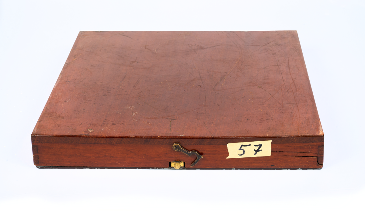 Kollisions-tavla, Ekelöfs patent, bestående av vit kompasssros med två rörliga farygsmodeller jämte visare, fästade till en rund bottenplatta, alltsammans monterat till en brunmålad, fyrkantig bottenplatta med lock av mahogny. Tillhörande tryckt beskrivning. Stockholm, 1892.