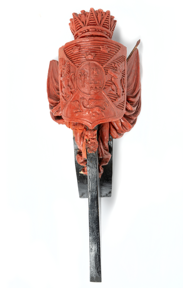 Vapensköld med Bernadottes hjärtvapen samt fyra fält med Sveriges och Norges lejon, en grip samt tre kronor, krönt med hertiglig krona. Hertigen av Södermanland Prins Oscar. Skölden flankeras av två fanor med stänger på var sida. Nedtill serafimerkedja. Monterad till stävkonstruktion av svartmålat trä.