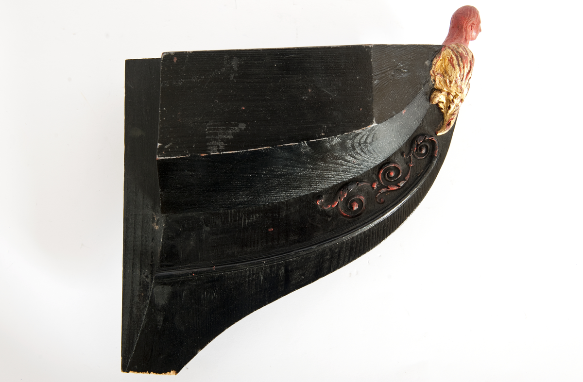 NORRKÖPINGs galjon. Vapensköld krönt av hjälm. På sköldens refflade botten krönt” N” kommandostäv och bila . På sidorna stiliserat bladverk. Monterad på stävkonstruktion av svartmålat trä, bogspröt. Omålat. röd vax