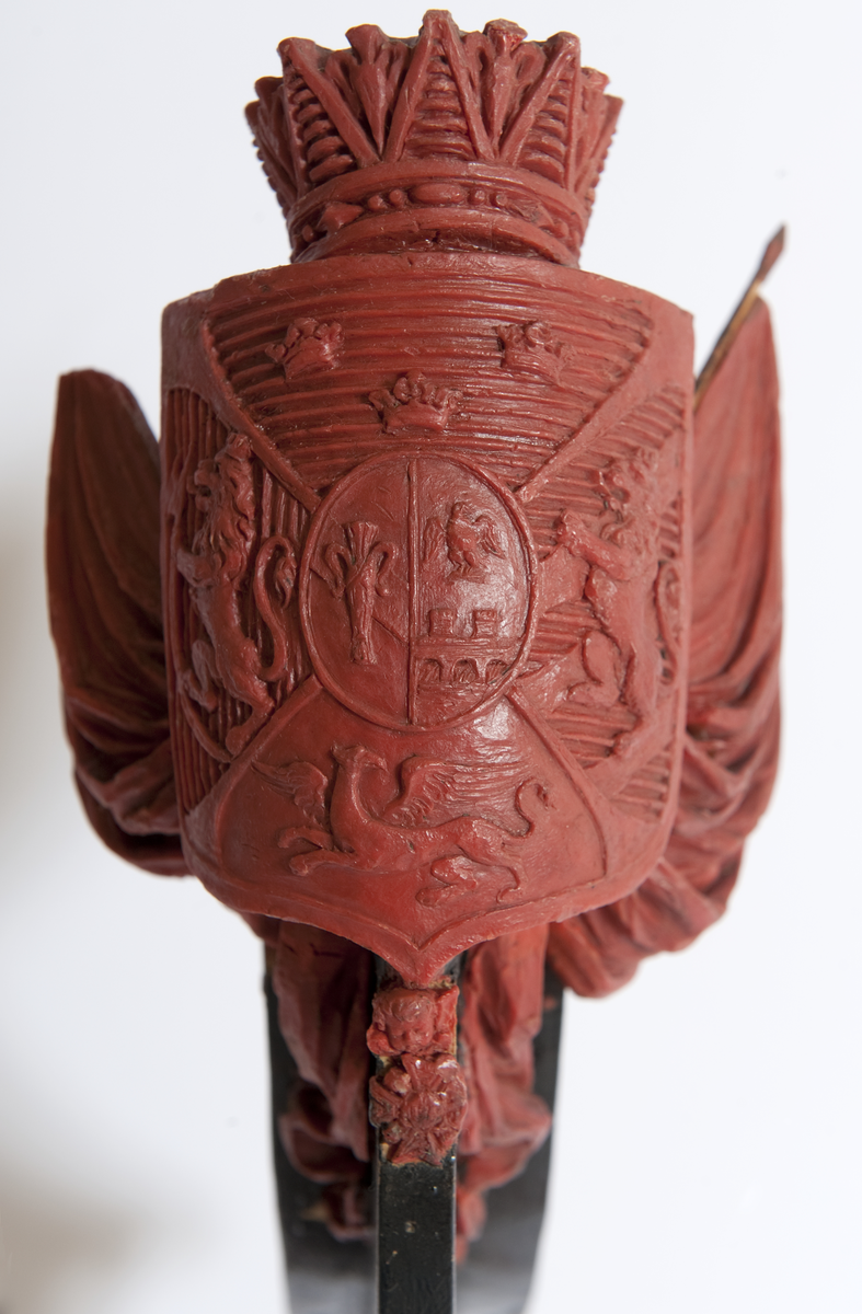 Vapensköld med Bernadottes hjärtvapen samt fyra fält med Sveriges och Norges lejon, en grip samt tre kronor, krönt med hertiglig krona. Hertigen av Södermanland Prins Oscar. Skölden flankeras av två fanor med stänger på var sida. Nedtill serafimerkedja. Monterad till stävkonstruktion av svartmålat trä.