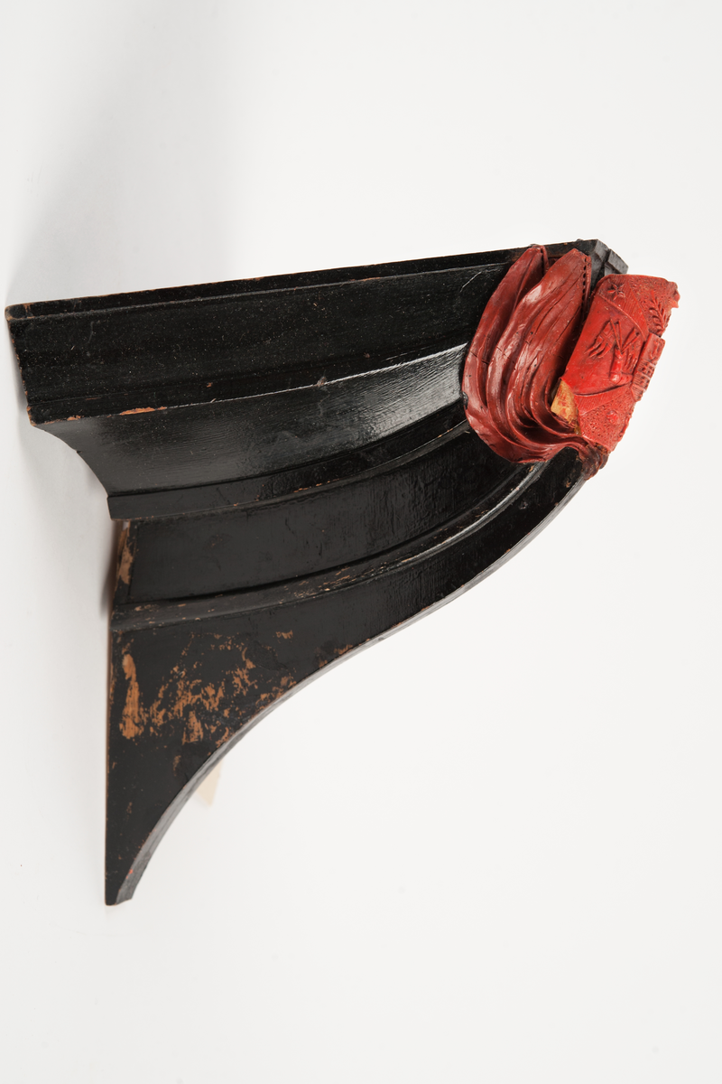 Föreställande korvetten LAGERBJELKEs vapensköld, omgiven av 2 flaggor på var sida. Monterad till stävkonstruktion av svartmålat trä med del av gråmålad bogspröt.
Röd vax.