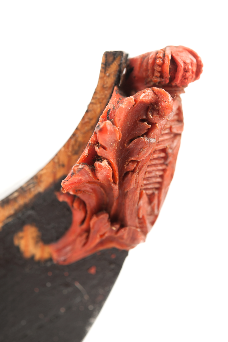 Föreställande korvetten KARLSKRONAs galjon. Stadsvapnet med kunglig krona över och bladverk på sidorna. Monterad till stävkonstruktion av svartmålat trä , fästad till gråmålad träplatta. Plattan: 170 x 85mm Korett. Röd vax.