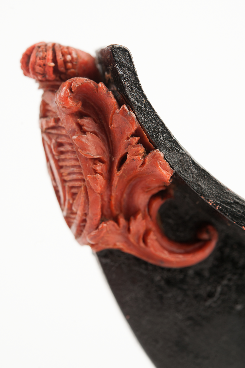 Föreställande korvetten KARLSKRONAs galjon. Stadsvapnet med kunglig krona över och bladverk på sidorna. Monterad till stävkonstruktion av svartmålat trä , fästad till gråmålad träplatta. Plattan: 170 x 85mm Korett. Röd vax.