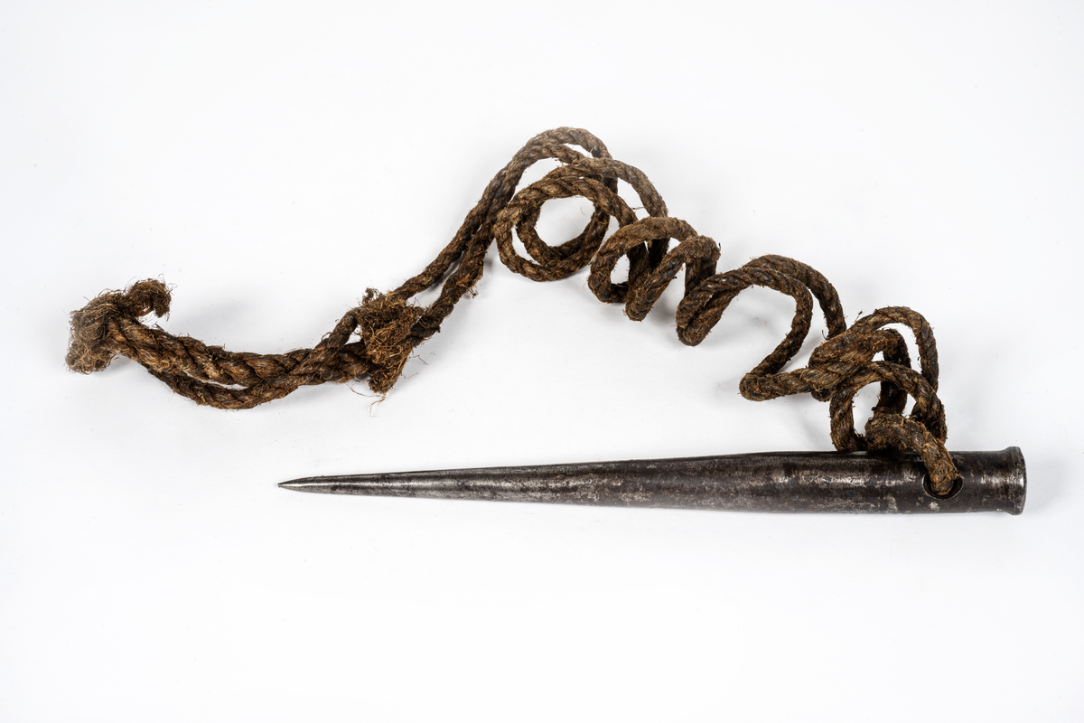 Märlspik av järn. Hål i överkant. Rep fästad i hålet.