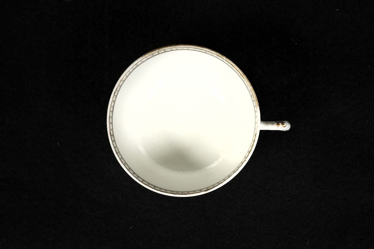 Med inbränd ornering, krönt med en hjälm. 3 våglinjer, vid horisonten en sol. Till vänster akterskepp med svensk flagga. Till höger en oktant, nedtill en vågbrytare samt ett ankare.
Ur servis som tillhört amiral Fredrik Henrik af Chapman, utförd på beställning i Kina.