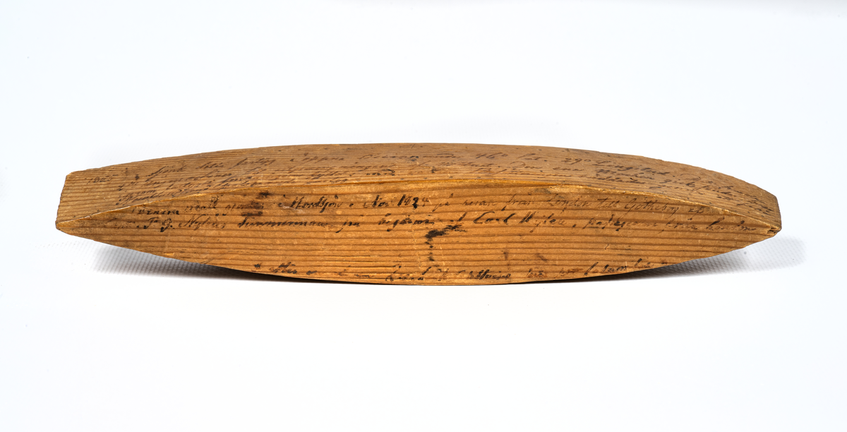 Vattenlinjemodell i trä med inskription.