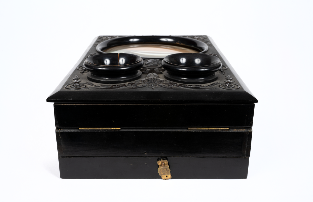 Svarlackad stereoskop med dekorerad ovansida och tre linser. Tillbehör finns.