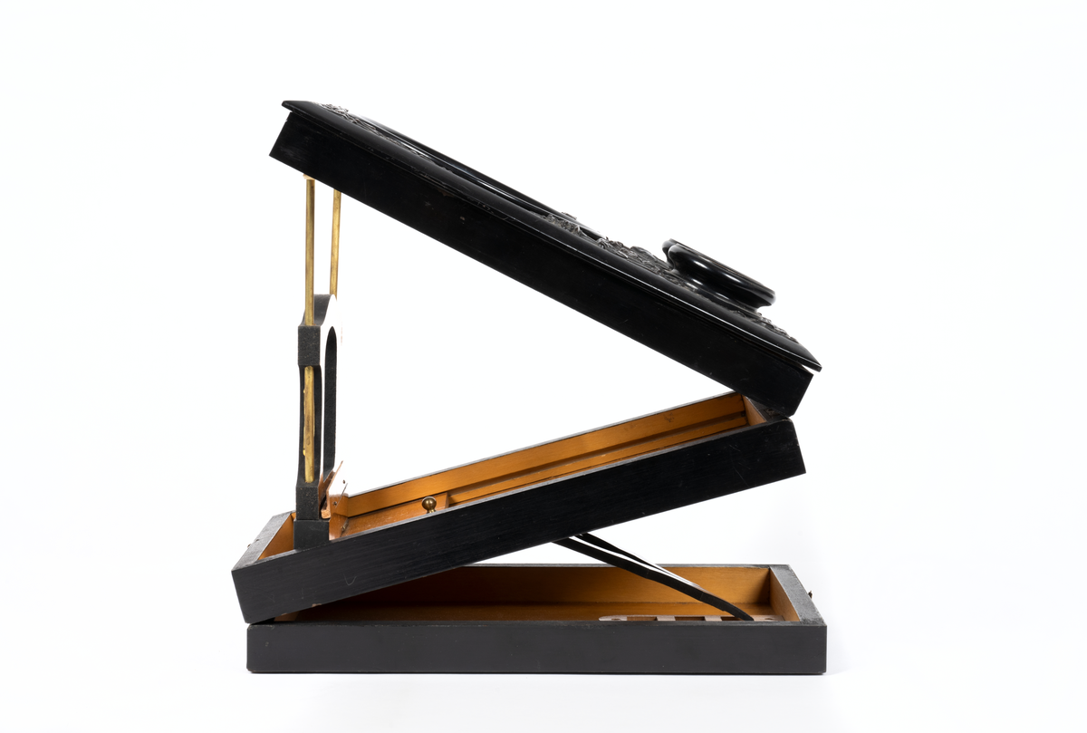 Svarlackad stereoskop med dekorerad ovansida och tre linser. Tillbehör finns.