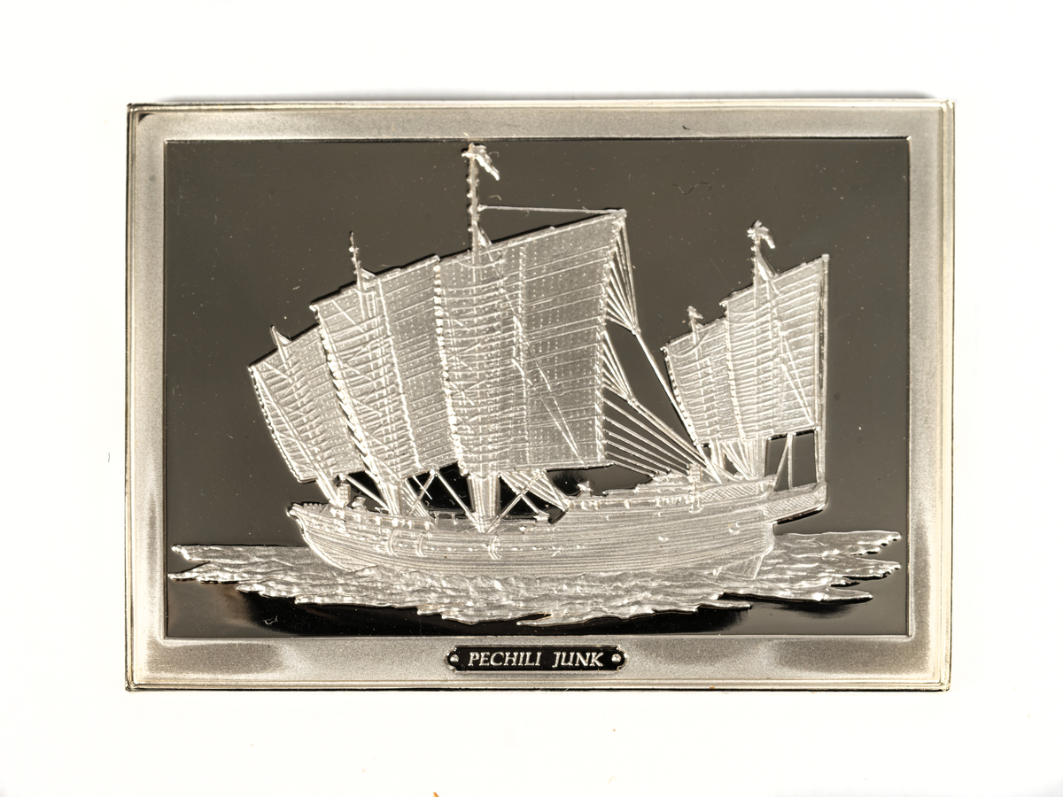Rektangulär silverplakett föreställande en kinesisk djonk från 1900-talet. Denna typ kallades pechili djonk.