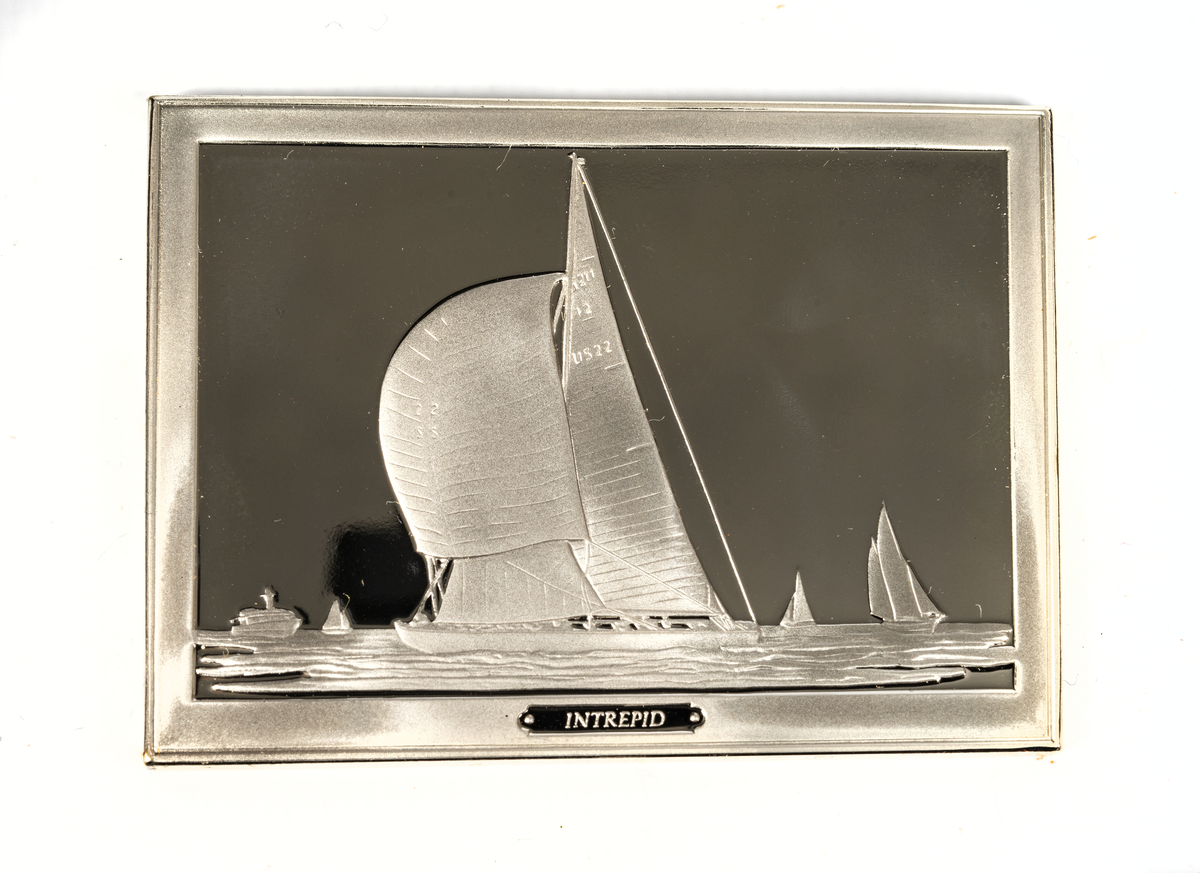 Rektangulär silverplakett föreställande INTREPID från 1970. 12-metersjakten INTREPID vann America's Cup 1967 och 1970.