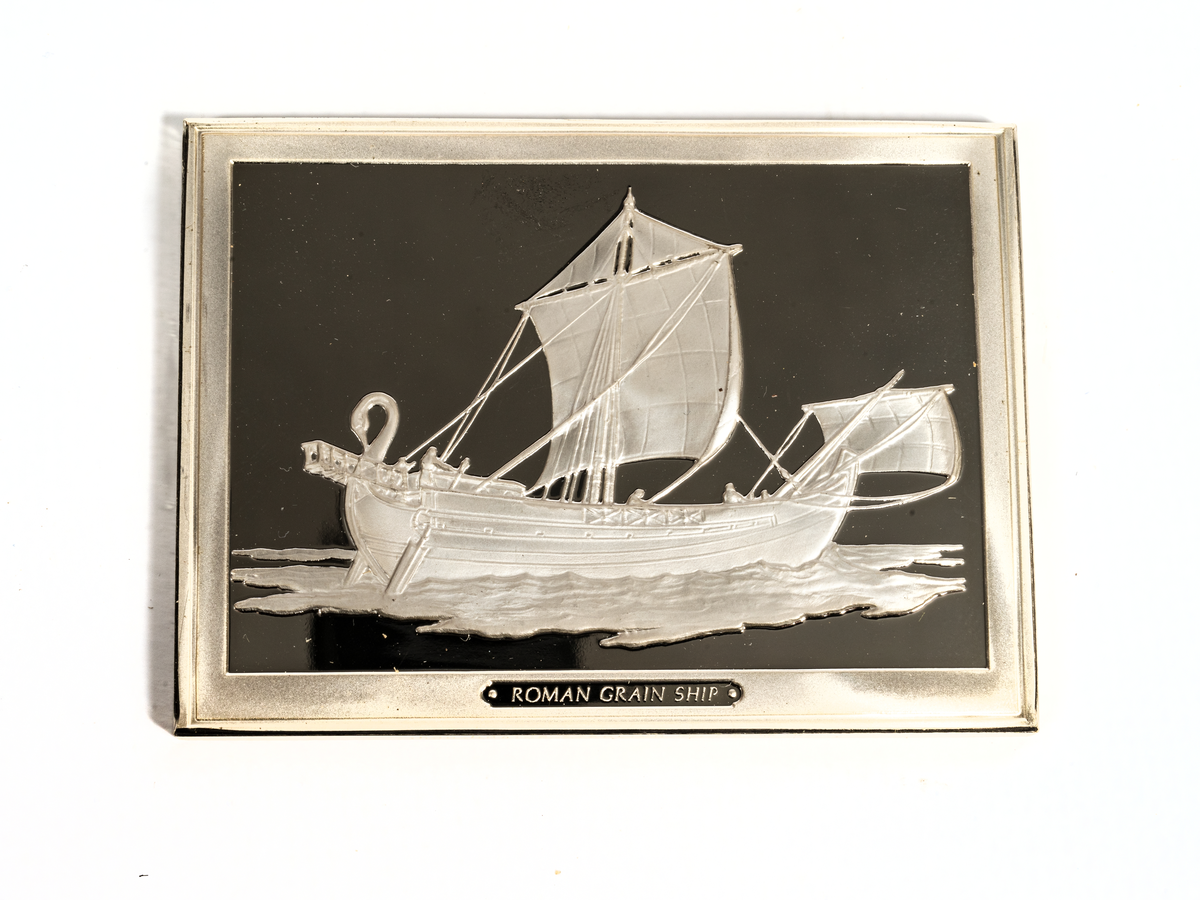 Rektangulär silverplakett föreställande ett romerskt spannmålsskepp från 100-talet e-Kr.