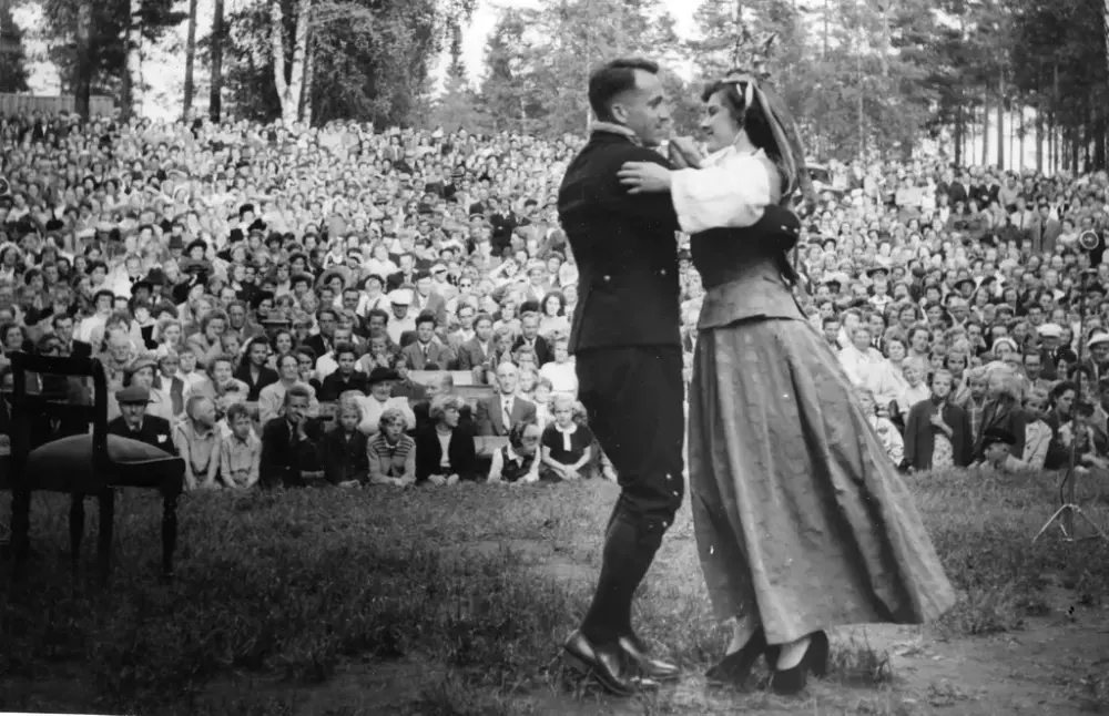 Et par danser foran et publikum, utendørs