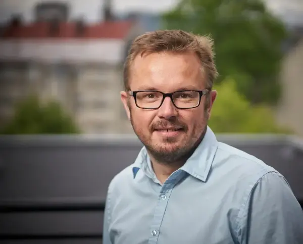 portrett av mann med briller i blå skjorte