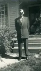 Portrett av Josef Thomasen Midttveit i dress utanfor inngang