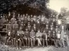 Arbetslag vid Reijmyre glasbruk samlade för fotografering runt hyttmästaren. Foto 1902 möjligen 1903.