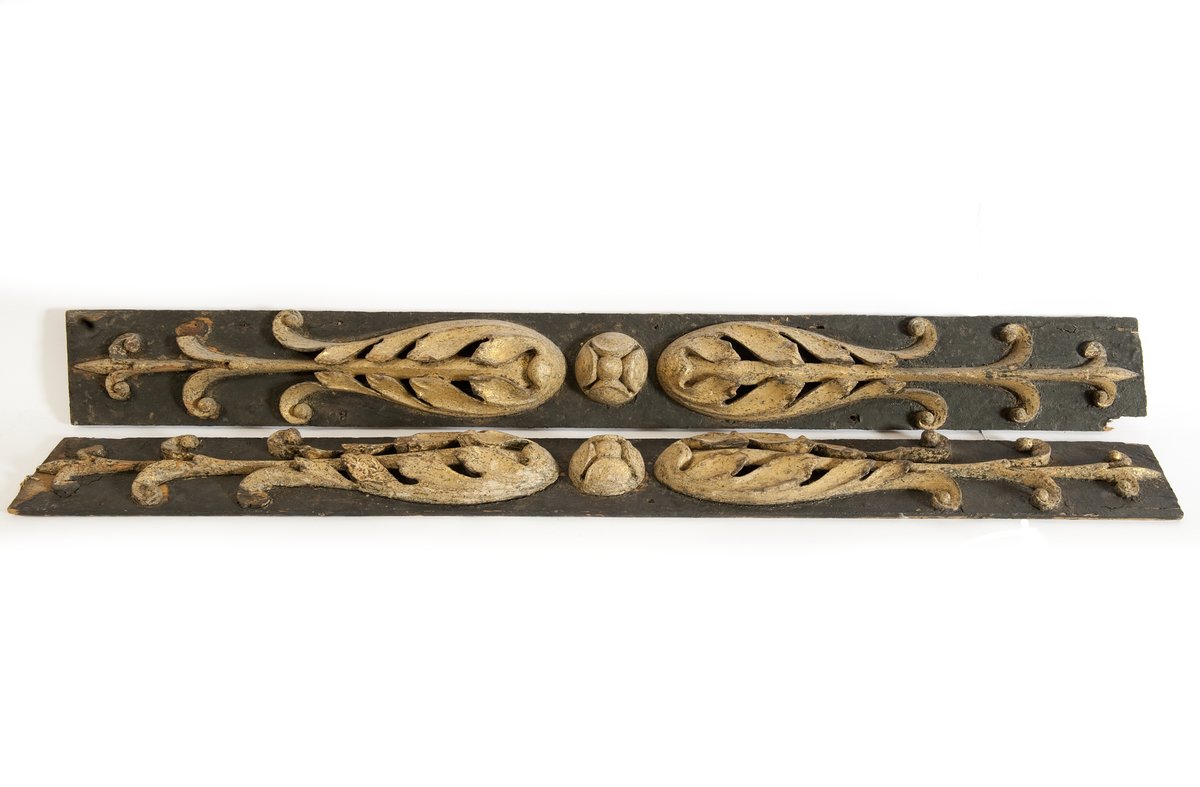 Pilastrar till EUGENIE, akterspegel.
Med skulpterade blommor, gulmålade, på underliggande förgyllning, monterade på plan av svartmålat trä.