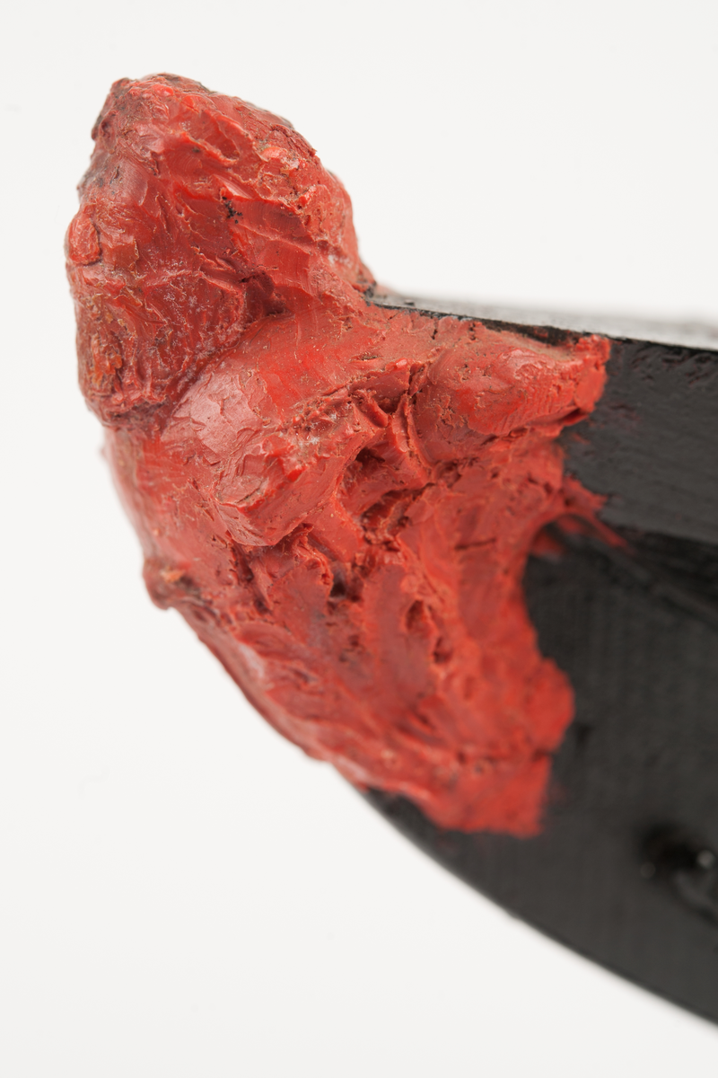 Ångkorvetten THORs galjon. Bröstbild av guden Thor  med hammare och brandfackla, samt akantusblad. Modelleringen skisserad. Monterad på stävkonstruktion av svartmålat trä, fästad till platta. Platta: 175x100 mm. Röd vax.