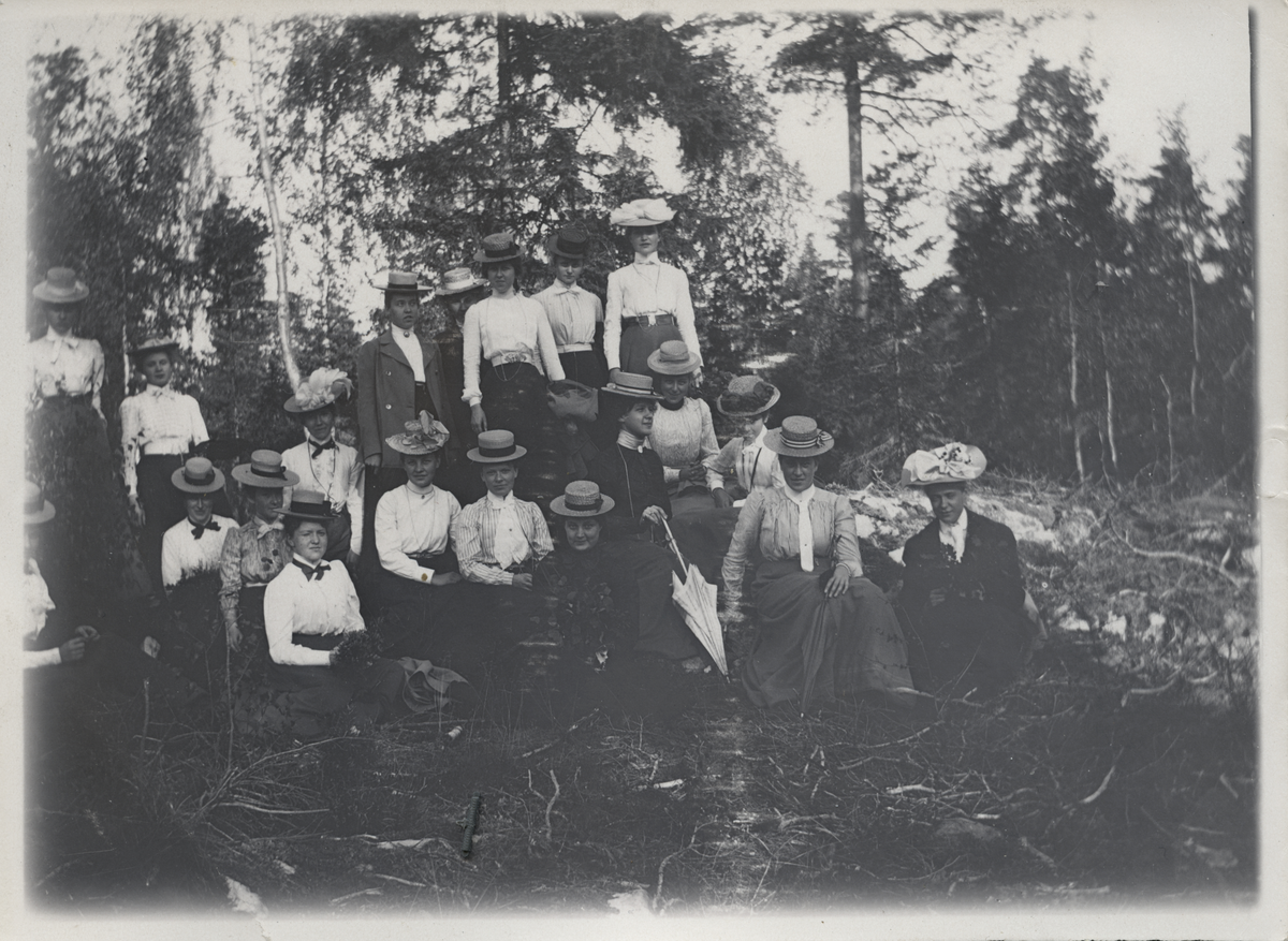 Grupporträtt av kvinnor som sitter i en skogsbacke.