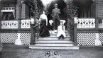 Foto av kvinna, man och barn på verandan till Gröndal, 1910.