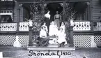 Foto av kvinnor och barn som sitter framför verandan på Gröndal, 1910. Text baksida kort: 