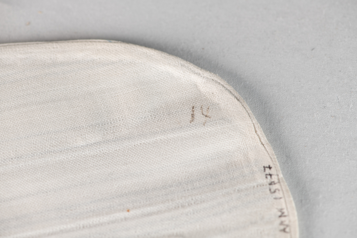  Løst skjortebryst i barnestørrelse. Hvit med smale blå striper. En midtfold  og to sidelegg. Påskrevet  G. F., som står for Gjeruld  Fløistad (d. 1973). Med vaskeriblekk påskrevet: 14.  Litt gulnet i halsen. 