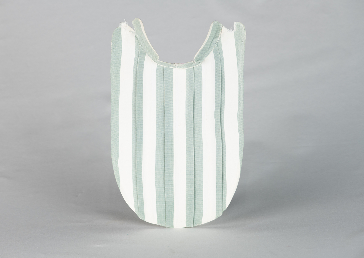 Løst skjortebryst i barnestørrelse.  Hvit med brede, grønne striper. Midtfold og to sidefolder. Påskrevet  G. F., som står for Gjeruld  Fløistad. Med vaskeblekk: 14. 