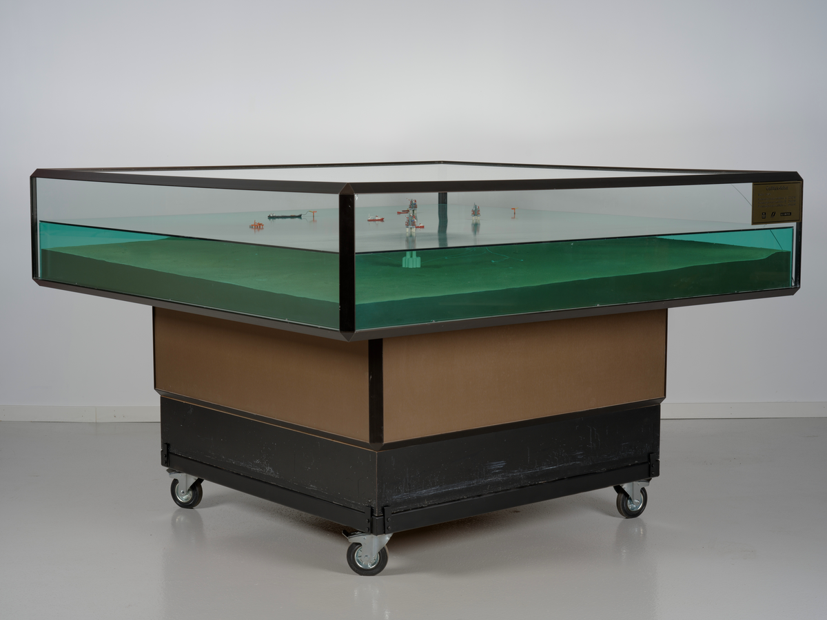 Modell av Gullfaksfeltet i monter med sokkel.

Modellen viser de tre integrerte prosess-, bore-, og boligplattformene Gullfaks A, Gullfaks B og Gullfaks C med understell av betong. Modellen viser hvordan disse installasjonene er plassert på havbunnen, og nettverket av rørledninger hvor blant annet noen er koblet opp til to lastebøyer. Et lasteskip er koblet opp til den ene lastebøyen.