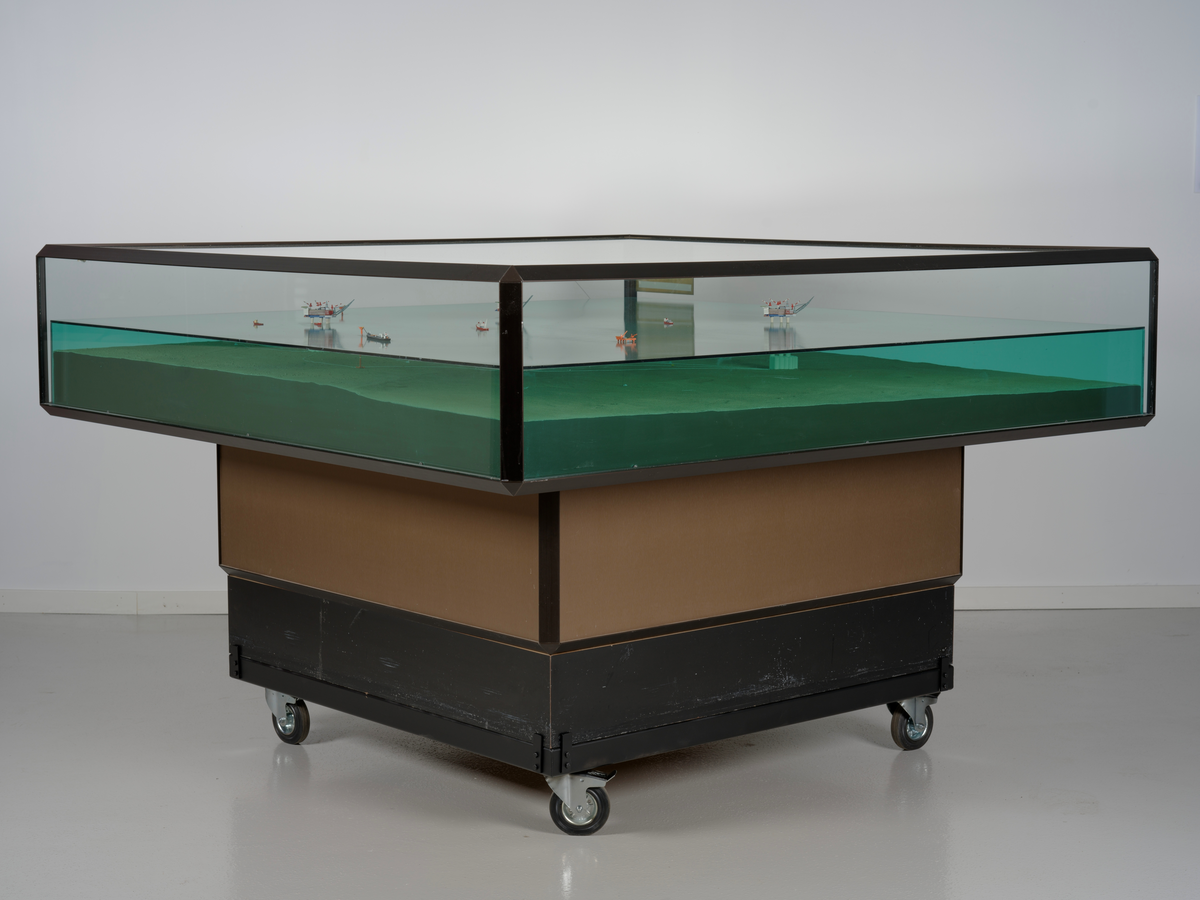 Modell av Gullfaksfeltet i monter med sokkel.

Modellen viser de tre integrerte prosess-, bore-, og boligplattformene Gullfaks A, Gullfaks B og Gullfaks C med understell av betong. Modellen viser hvordan disse installasjonene er plassert på havbunnen, og nettverket av rørledninger hvor blant annet noen er koblet opp til to lastebøyer. Et lasteskip er koblet opp til den ene lastebøyen.