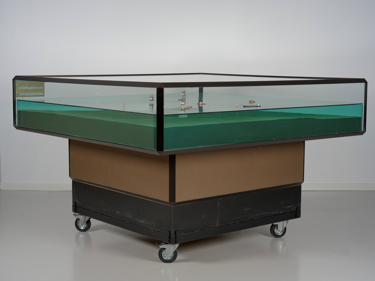 Modell av Gullfaksfeltet i monter med sokkel.

Modellen viser de tre integrerte prosess-, bore-, og boligplattformene Gullfaks A, Gullfaks B og Gullfaks C med understell av betong. Modellen viser hvordan disse installasjonene er plassert på havbunnen, og nettverket av rørledninger hvor blant annet noen er koblet opp til to lastebøyer. Et lasteskip er koblet opp til den ene lastebøyen.