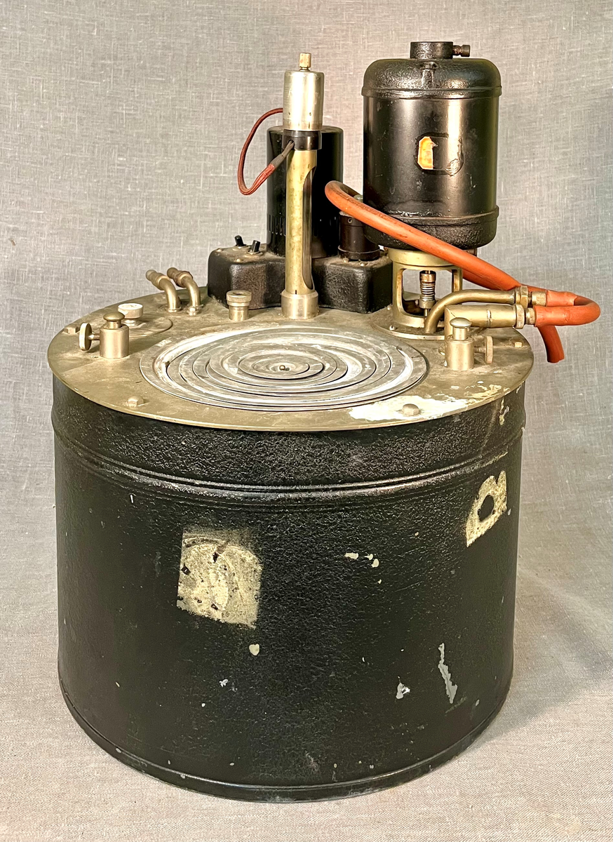 Instrument for vannbad med kvikksølvtermostat og sirkulasjonspumpe for tilkobling til andre instrumenter og tilkobling til kaldt vann. Instrumentet har en "kokeplate" i form av en rund åpning, der løse metallringer kan fjernes for å tilpasse åpningen til størrelsen på kolber som skal varmes.