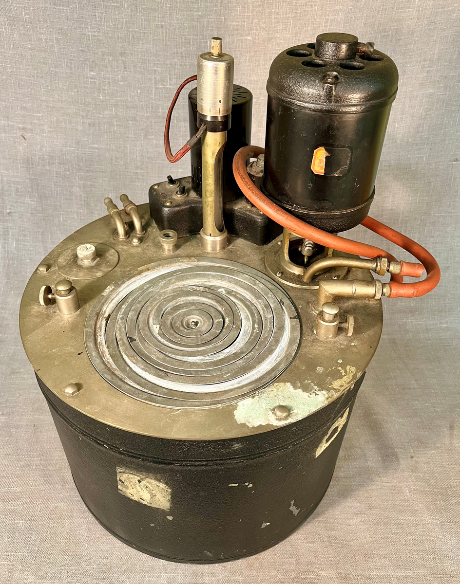 Instrument for vannbad med kvikksølvtermostat og sirkulasjonspumpe for tilkobling til andre instrumenter og tilkobling til kaldt vann. Instrumentet har en "kokeplate" i form av en rund åpning, der løse metallringer kan fjernes for å tilpasse åpningen til størrelsen på kolber som skal varmes.