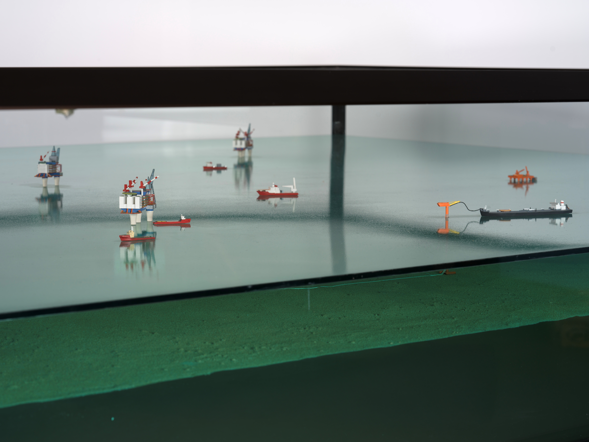 Modell av Gullfaksfeltet i monter med sokkel.

Modellen viser de tre integrerte prosess-, bore-, og boligplattformene Gullfaks A, Gullfaks B og Gullfaks C med understell av betong. Modellen viser hvordan disse installasjonene er plassert på havbunnen, og nettverket av rørledninger hvor blant annet noen er koblet opp til to lastebøyer. Et lasteskip er koblet opp til den ene lastebøyen.