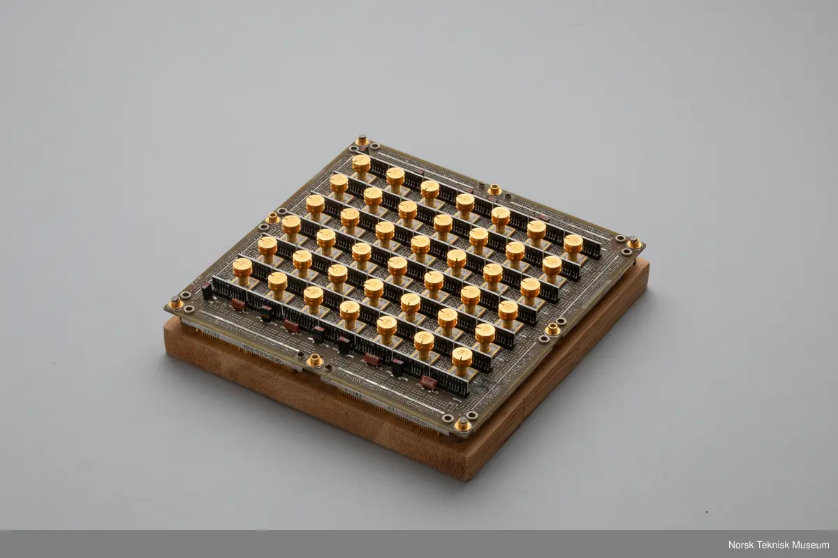 Kretskort med 42 microchips med særegne kjøletårn. Kortet er tatt ut av maskinen, Amdahl 470, og montert på en treplate, trolig som en souvenir / pybtegjenstand. Selve maskinen er ikke bevart, så vidt vi vet.