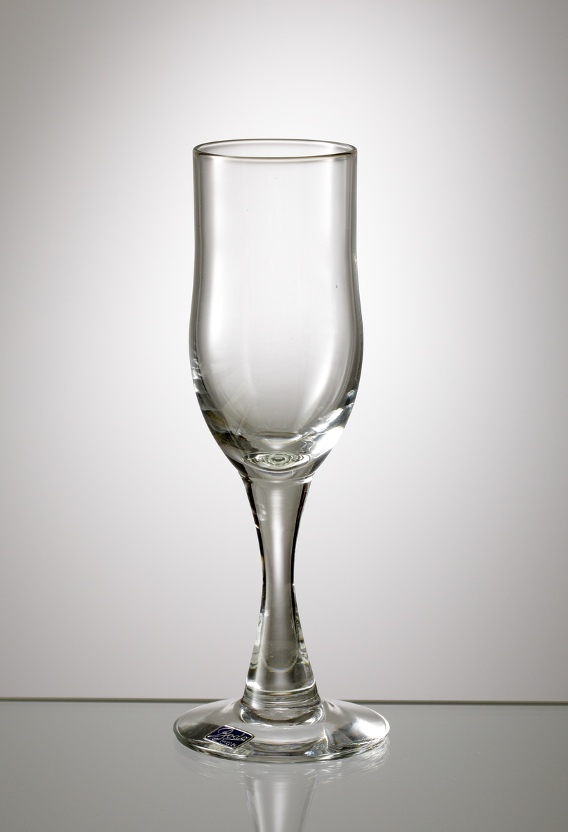 Starkvinsglas tillhörande servis "H 1".
Formgivet av Erik Höglund eller Kallenberg.
Möjligen tillverkat 1960.
Cylindrisk skål, avrundad nedåt. Konkavt ben.
Ofärgat klarglas.
Ovan angivna mått avser övre diameter.
Inskrivet i huvudkatalogen 1968.
Funktion: Starkvinsglas