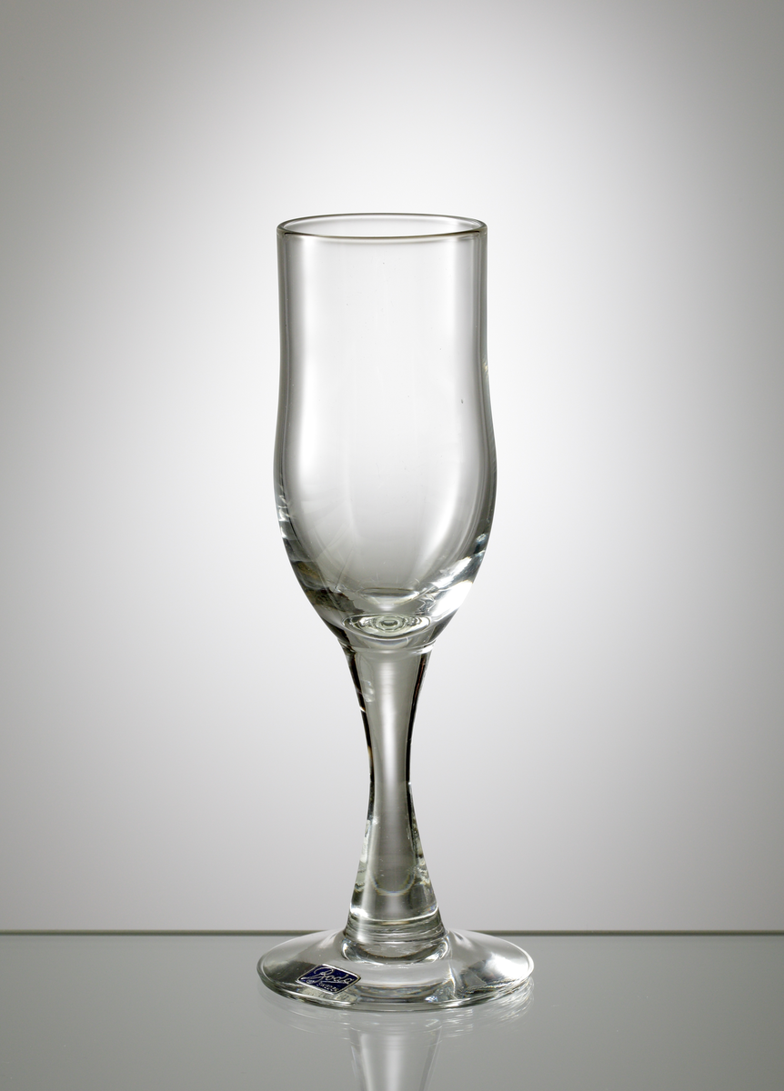 Starkvinsglas tillhörande servis "H 1".
Formgivet av Erik Höglund eller Kallenberg.
Möjligen tillverkat 1960.
Cylindrisk skål, avrundad nedåt. Konkavt ben.
Ofärgat klarglas.
Ovan angivna mått avser övre diameter.
Inskrivet i huvudkatalogen 1968.
Funktion: Starkvinsglas