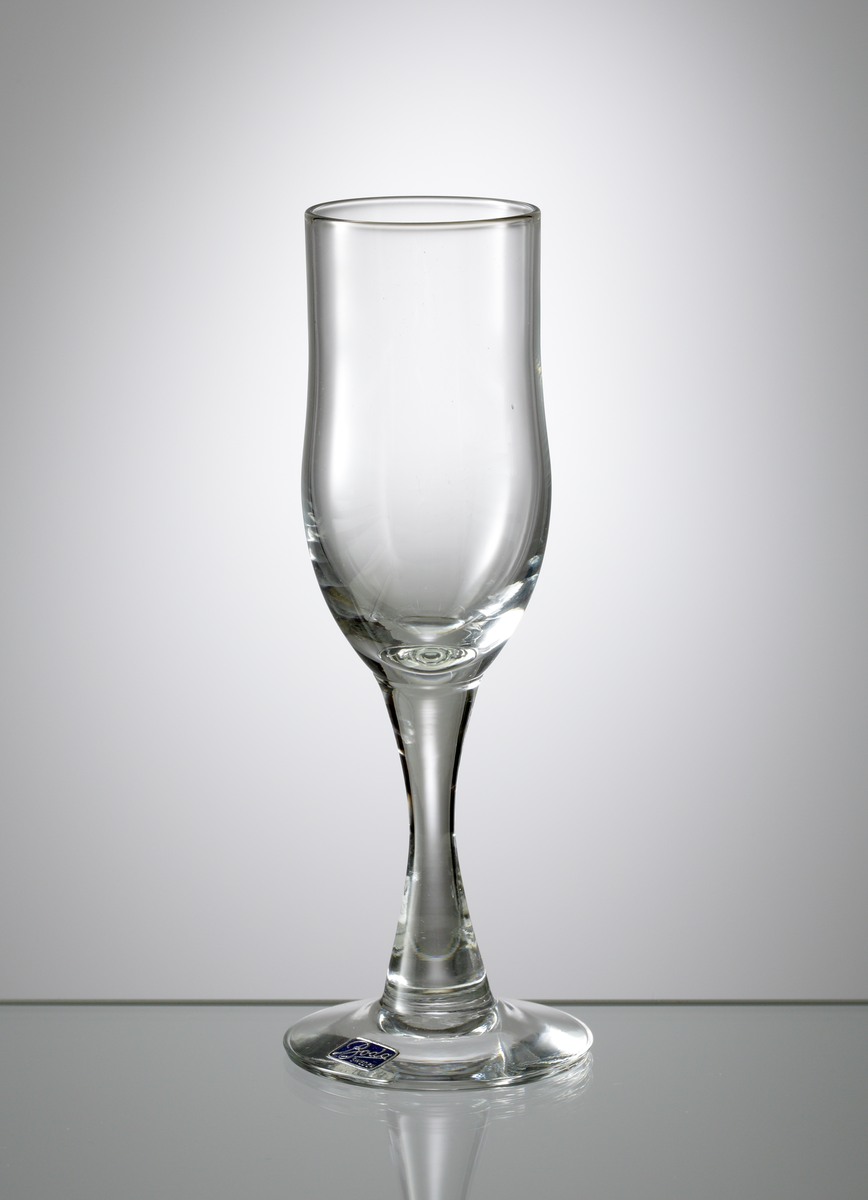 Starkvinsglas tillhörande servis "H 1".
Formgivet av Erik Höglund eller Kallenberg.
Möjligen tillverkat 1960.
Cylindrisk skål, avrundad nedåt. Konkavt ben.
Ofärgat klarglas.
Ovan angivna mått avser övre diameter.
Inskrivet i huvudkatalogen 1968.
Funktion: Starkvinsglas