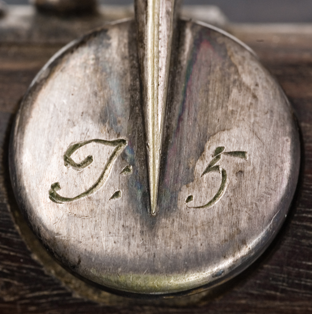 Tvärflöjt i mörkt trä med metallringar. Böhmsystem, delvis med öppna klaffar. 3 delar. Sprickor i munstycke. Fot ej original. Dålig kondition. A=459.