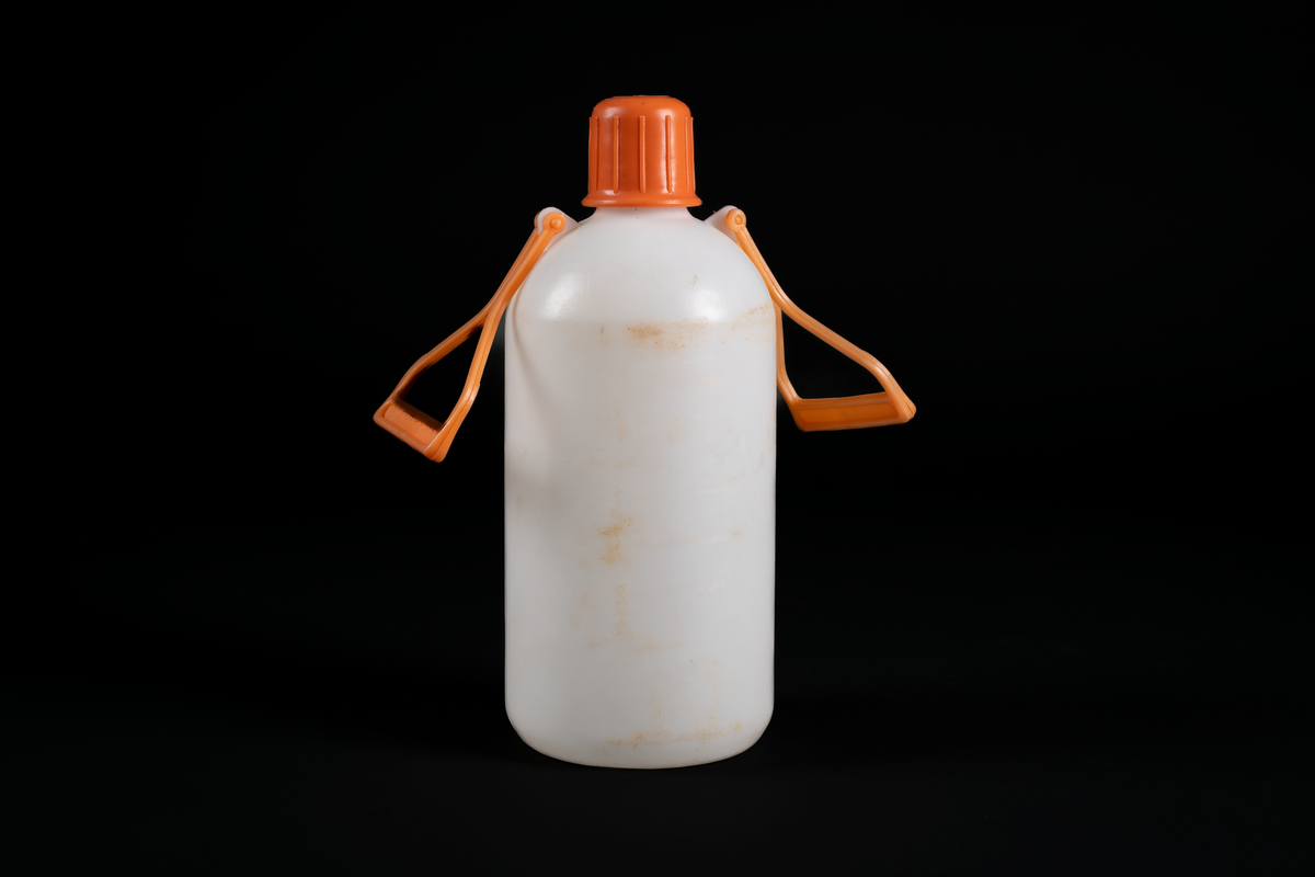 Vattendunk i vit plast med orange kork och två orange handtag på motsatta sidor.