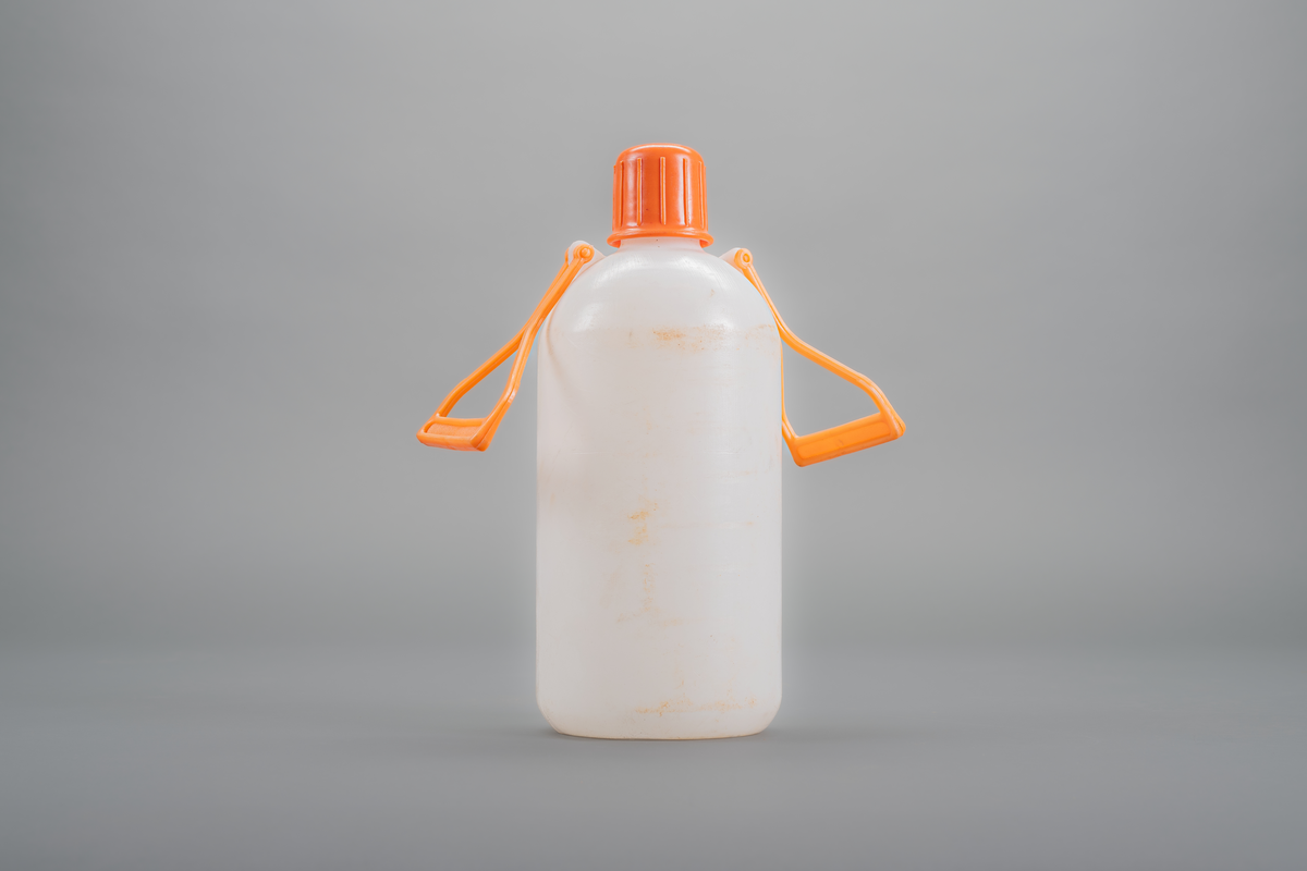 Vattendunk i vit plast med orange kork och två orange handtag på motsatta sidor.