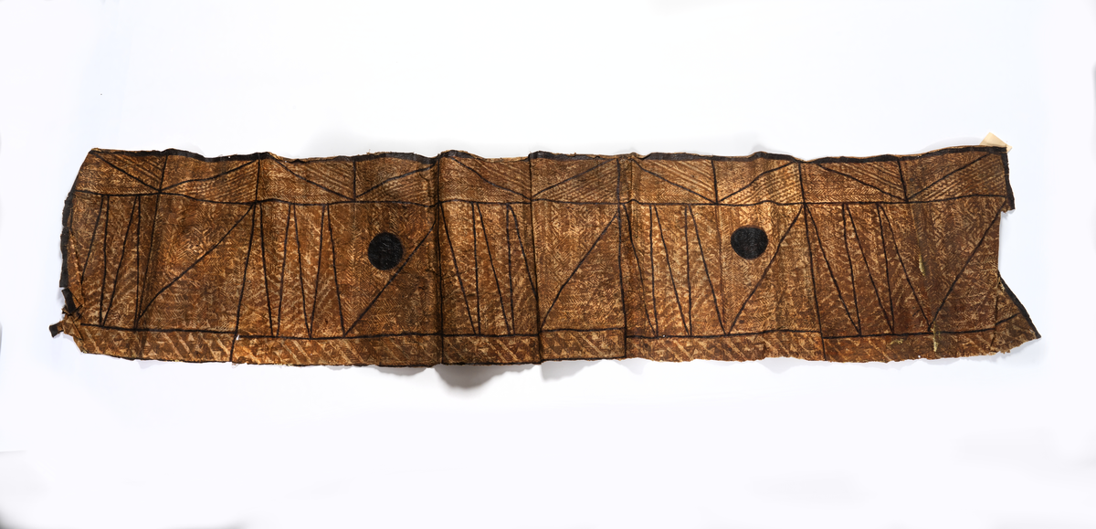 Tapa från Samoa. 
Mönster i brun färg, svarta ränder samt två cirklar i svartbrun färg.