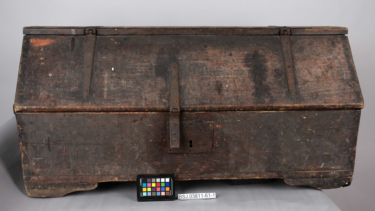 Tømmermannskiste. Kiste med åpning i front med beslag av jern for feste av lokk samt låskasse. Trehåndtak på hver kortside. Innvendig løs skuff og opphengsbeslag for bor og navar ol.