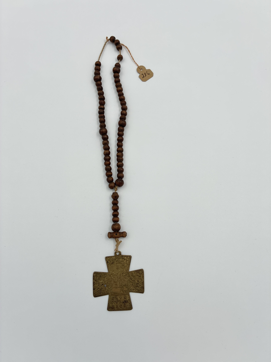 Radband med träkulor och mässingskors i form av ett Sankt Georgskors. På ena sidan av korset en scen kopplad till Lechfeldslaget 955 e.Kr samt texten "CRVX S:VDAL RICI" vilket syftar på att korset är tillägnat Sankt Ulrik. 

På korsets andra sida syns Sankt Ulrik, Sankt Benedikt och Sankt Afra. 

En gåva till givaren av rådman Siljeström.