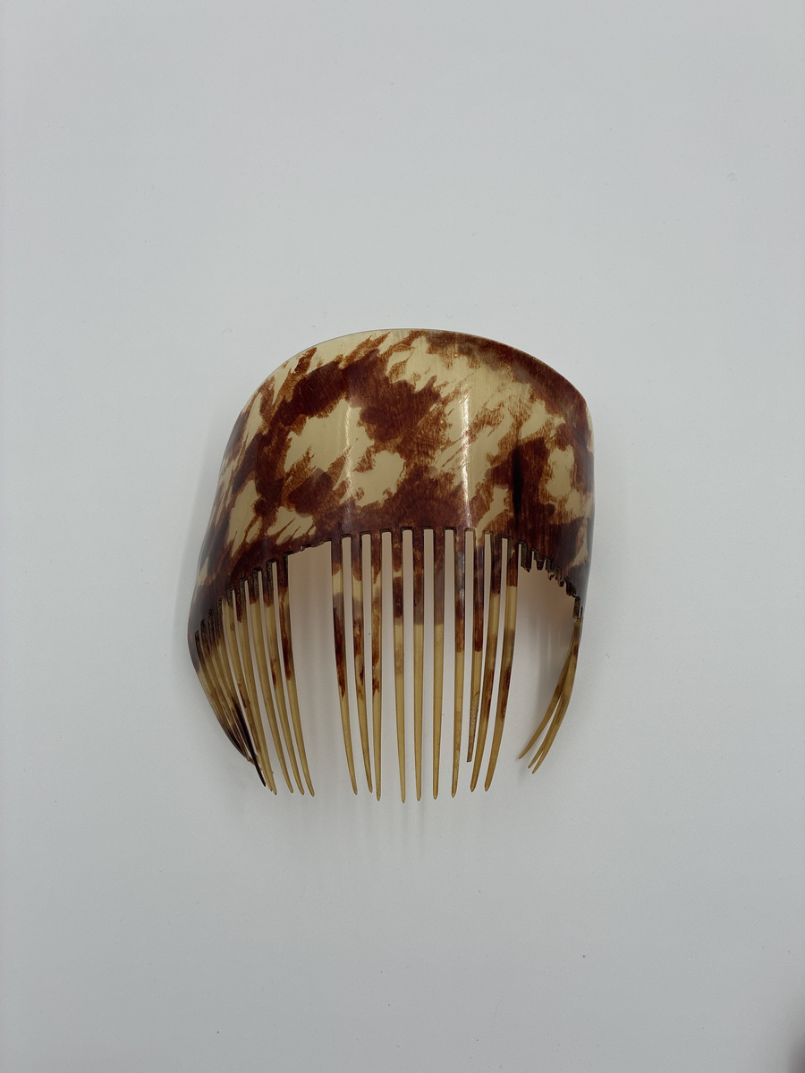 Hårkam av sköldpaddsliknande material. 
Tillvaratagen på Samrealskolans vind.
