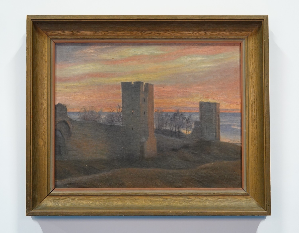 Landskapsbild med motiv från Visby. I förgrunden Visby ringmur. I bakgrunden kala träd och hav. Motivet är avbildat i skymningen, himlen är orange i olika nyanser.